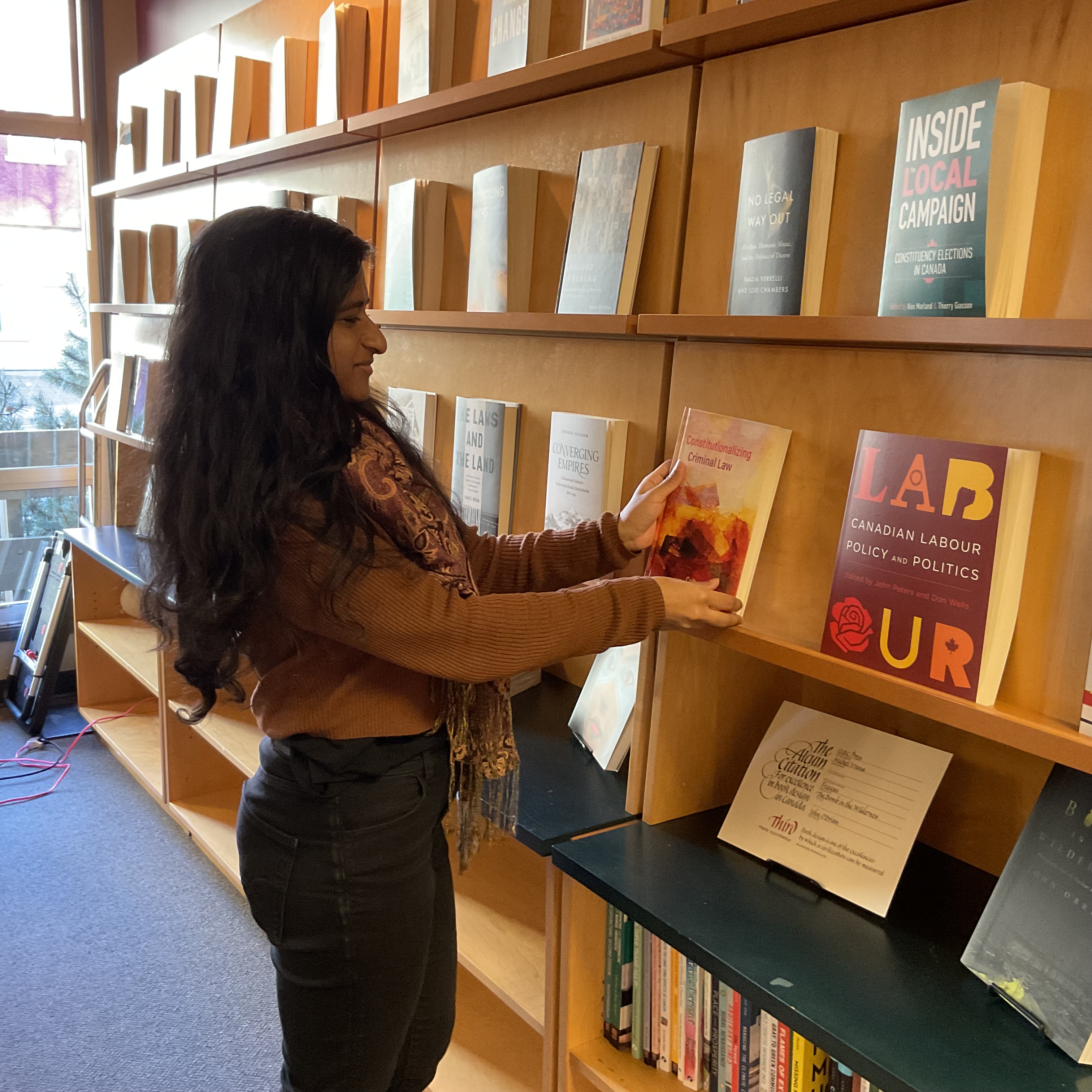 Publishing Clerk Shalini Nannayakkara placing a book on a display shelf